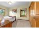 Cozy bedroom featuring carpet, windows, and a wood paneled closet at 17995 Minglewood Trl, Monument, CO 80132