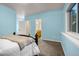 Comfortable bedroom with cozy carpet, blue walls and a view of nature through a large window at 17995 Minglewood Trl, Monument, CO 80132