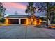 Front exterior of home at dusk featuring a spacious driveway and a three car garage at 17995 Minglewood Trl, Monument, CO 80132