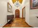 Elegant foyer features a beautiful chandelier and an arched, carved wood front door at 17995 Minglewood Trl, Monument, CO 80132