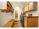 Well-organized laundry room with custom wooden cabinets, bench, and modern washer and dryer at 17995 Minglewood Trl, Monument, CO 80132