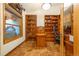 Well-appointed office with custom built-in wooden bookshelves and ample natural light at 17995 Minglewood Trl, Monument, CO 80132