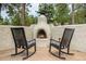 Inviting outdoor area featuring a stone fireplace and comfortable rocking chairs at 17995 Minglewood Trl, Monument, CO 80132