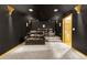 A cozy home theater boasts comfortable seating on carpeted tiers, with unique lighting and black painted walls at 17995 Minglewood Trl, Monument, CO 80132