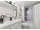 Modern bathroom featuring a white vanity, black fixtures, and a shower over a tub with marble-look tile at 601 W 11Th Ave # 910, Denver, CO 80204