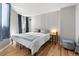 Bedroom featuring light gray walls, hardwood floors, and modern blue curtains and ottoman at 601 W 11Th Ave # 910, Denver, CO 80204