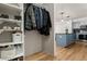 Hallway with organized closet space on the left and a kitchen in the background at 601 W 11Th Ave # 910, Denver, CO 80204