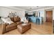 Open-concept living room flowing into the kitchen featuring hardwood floors and a leather sectional couch at 601 W 11Th Ave # 910, Denver, CO 80204