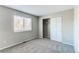 This bedroom offers plush gray carpeting, a large window, and a closet with paneled doors at 10406 Drake Pl, Parker, CO 80134