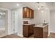 Stylish basement bar area complete with sink, seating, and wood cabinetry at 5523 E Utah Pl, Denver, CO 80222