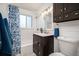 Cozy bathroom featuring a shower/tub combo, dark wood vanity, and white wainscoting at 5523 E Utah Pl, Denver, CO 80222