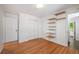 Bright bedroom features hardwood floors, shelving, and a closet for ample storage at 5523 E Utah Pl, Denver, CO 80222