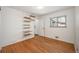 Bright bedroom featuring hardwood floors, ample natural light, and built-in shelving at 5523 E Utah Pl, Denver, CO 80222