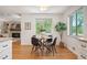 Bright dining area adjacent to the kitchen with hardwood floors and large windows overlooking a lush yard at 5523 E Utah Pl, Denver, CO 80222