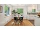 Open dining area with hardwood floors, large windows, and a view of the updated kitchen space at 5523 E Utah Pl, Denver, CO 80222