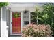 Close-up of a red front door with house number and flowering bushes in front of the property at 5523 E Utah Pl, Denver, CO 80222