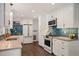 Bright kitchen featuring white cabinetry, stainless steel appliances, and a beautiful blue tiled backsplash at 5523 E Utah Pl, Denver, CO 80222
