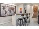 Finished basement wet bar with wooden counter, three stools, and world map art at 3227 Quivas St # 1, Denver, CO 80211