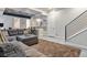 Finished basement with gray sofa, kitchenette, and modern metal staircase at 3227 Quivas St # 1, Denver, CO 80211
