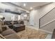 Finished basement with gray sectional couch, kitchenette, and modern metal staircase at 3227 Quivas St # 1, Denver, CO 80211