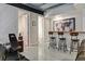 Finished basement wet bar with wooden counter, four stools, and world map art at 3227 Quivas St # 1, Denver, CO 80211