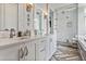 Luxurious bathroom featuring double sinks, quartz countertops, herringbone tile, and a glass-enclosed shower at 3227 Quivas St # 1, Denver, CO 80211