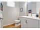Bright half bathroom with white vanity, modern fixtures, and wood-look flooring at 3227 Quivas St # 1, Denver, CO 80211