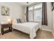 Cozy bedroom with a large window, comfortable bed with pillows and side table at 3227 Quivas St # 1, Denver, CO 80211