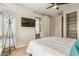 Modern bedroom with a TV, ceiling fan, and a sliding barn door leading to the bathroom at 3227 Quivas St # 1, Denver, CO 80211