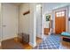 Welcoming entryway with wood flooring, coat rack, and view of the staircase at 3227 Quivas St # 1, Denver, CO 80211