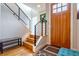 Bright foyer featuring hardwood floors, modern railing staircase and stained wood front door at 3227 Quivas St # 1, Denver, CO 80211