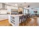 Beautiful kitchen with white cabinets, large island with seating, stainless appliances, and open to living area at 3227 Quivas St # 1, Denver, CO 80211