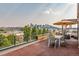 Entertaining roof deck boasting dining, seating, and a city view with shading umbrella at 3227 Quivas St # 1, Denver, CO 80211