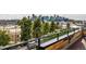 Stunning roof deck view with cityscape, lush trees, and modern railing at 3227 Quivas St # 1, Denver, CO 80211