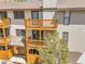 Charming condo featuring upper and lower balconies constructed with stained wood, shaded by a large pine tree at 1890 Argentine St # D203, Georgetown, CO 80444