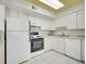 Well-lit kitchen featuring white appliances, ample counter space, and tile flooring at 1890 Argentine St # D203, Georgetown, CO 80444