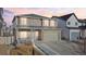 Charming two-story home with a two-car garage and welcoming front porch at dusk at 5318 Truckee St, Denver, CO 80249