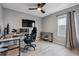 Office space with light wood floors, fan, window, and black-and-white furniture at 12863 Crane River Dr, Firestone, CO 80504