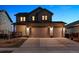 Charming two-story home with a three car garage and well-lit exterior for evening appeal at 12863 Crane River Dr, Firestone, CO 80504