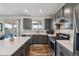 Modern kitchen with gray cabinets, stainless steel appliances, and quartz countertops at 12863 Crane River Dr, Firestone, CO 80504