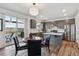 Modern kitchen featuring gray cabinets, stainless steel appliances, an island, and a dining area with deck access at 12863 Crane River Dr, Firestone, CO 80504