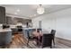 Open kitchen and dining area with gray cabinets, stainless appliances, and stylish lighting at 12863 Crane River Dr, Firestone, CO 80504