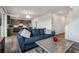 Comfortable living room features a blue sofa, stylish decor, and an open layout leading into the modern kitchen area at 12863 Crane River Dr, Firestone, CO 80504