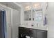 Bright bathroom featuring a double vanity sink, modern lighting, and a glass shower at 17826 E 107Th Way, Commerce City, CO 80022