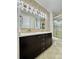 Modern bathroom featuring a double vanity, stylish lighting, and a tiled shower with glass door at 12213 Joplin St, Commerce City, CO 80603