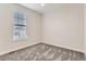 Bright, modern bedroom with neutral walls, soft gray carpet, and a large window at 12213 Joplin St, Commerce City, CO 80603