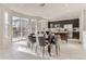 Bright dining area features modern lighting, dark wood table and view to kitchen and deck at 12213 Joplin St, Commerce City, CO 80603