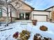 Charming home with a two-car garage and inviting front entrance during a winter snowfall at 12213 Joplin St, Commerce City, CO 80603