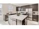 Modern kitchen with stainless steel appliances, dark cabinetry, and a quartz island at 12213 Joplin St, Commerce City, CO 80603