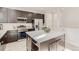 Modern kitchen featuring stainless steel appliances, dark cabinets, and a quartz topped island at 12213 Joplin St, Commerce City, CO 80603